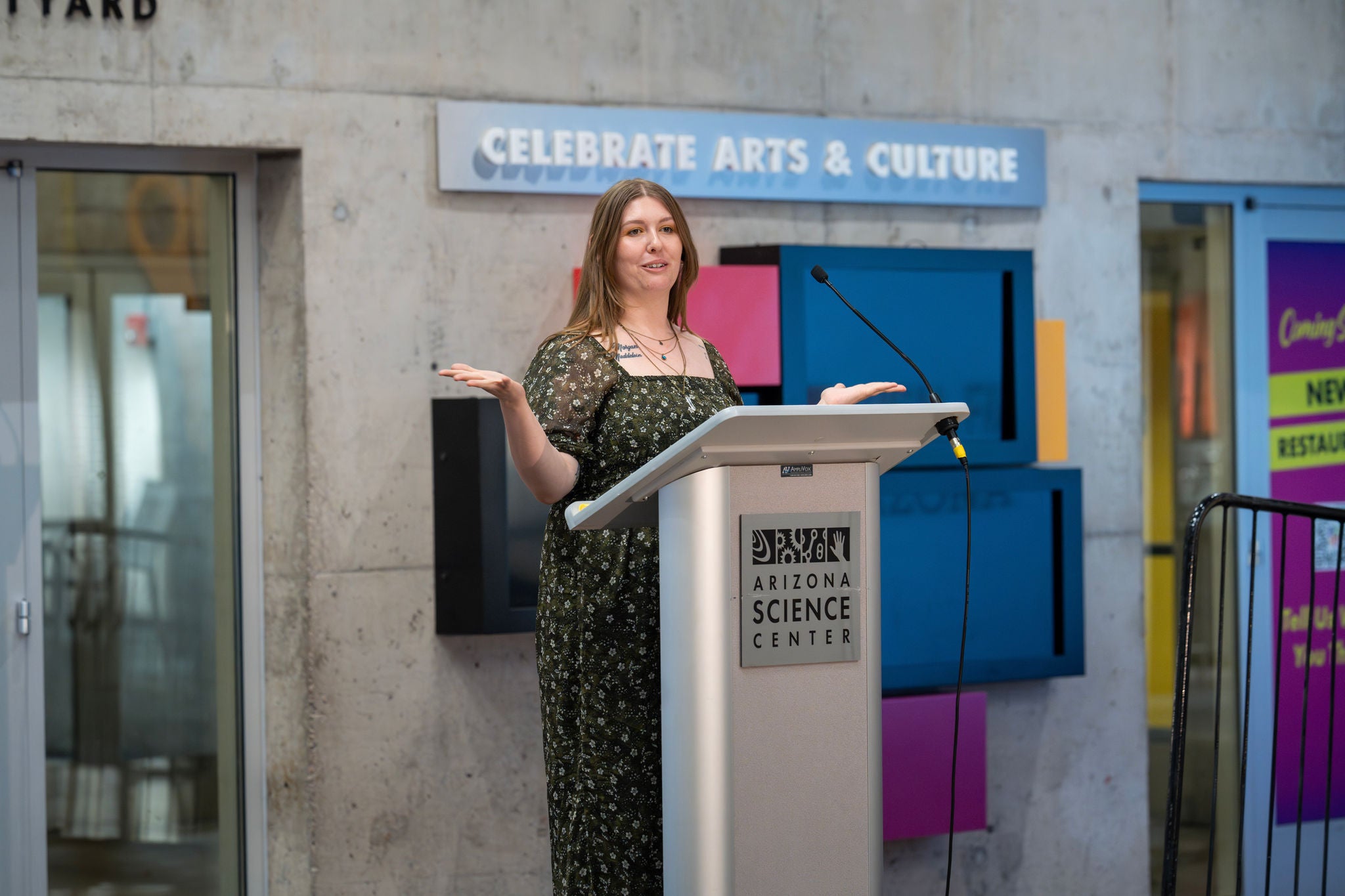 A speaker at the podium in the atrium of the Arizona Science Center