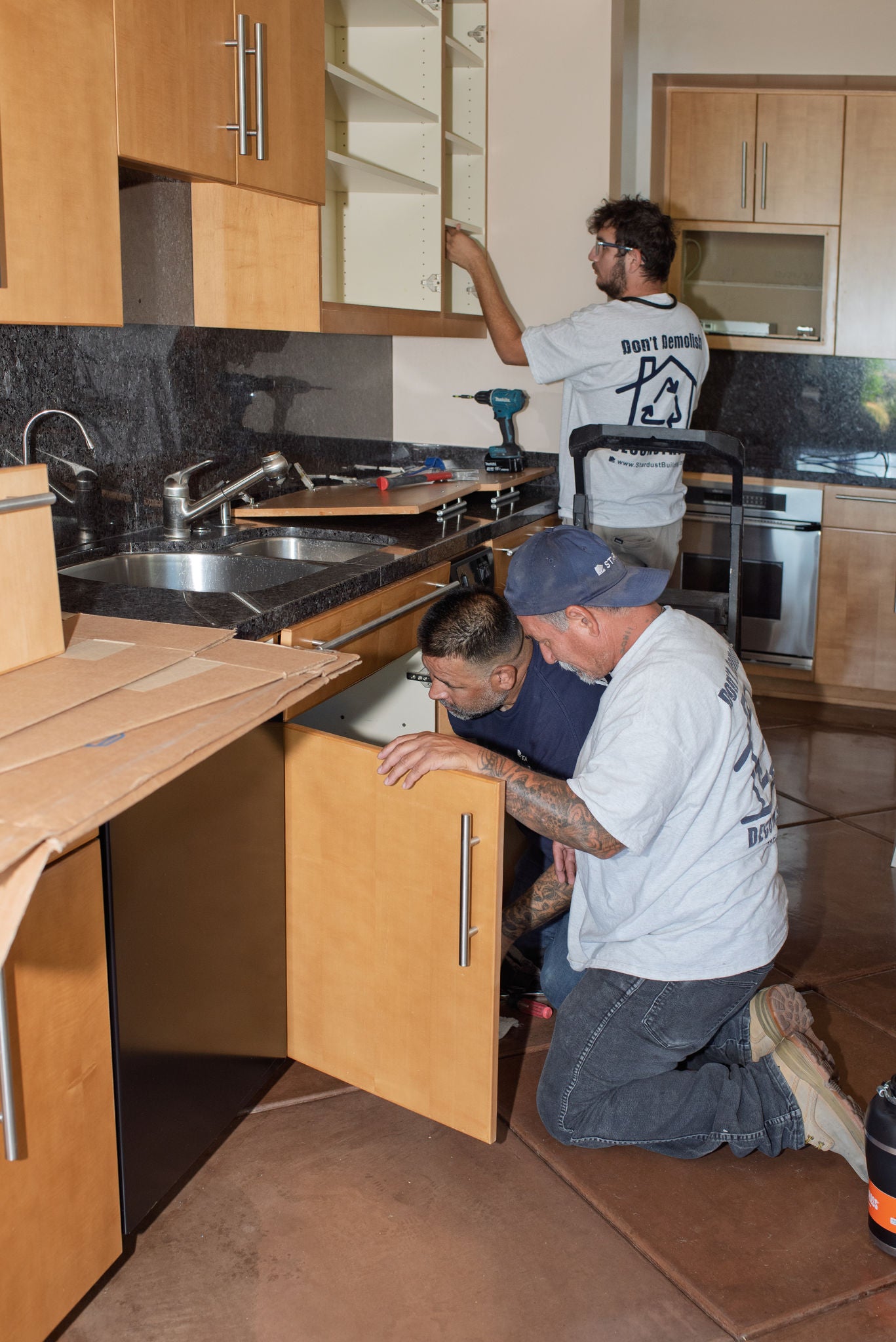 Workers carefully removing cabinets in a home demolition