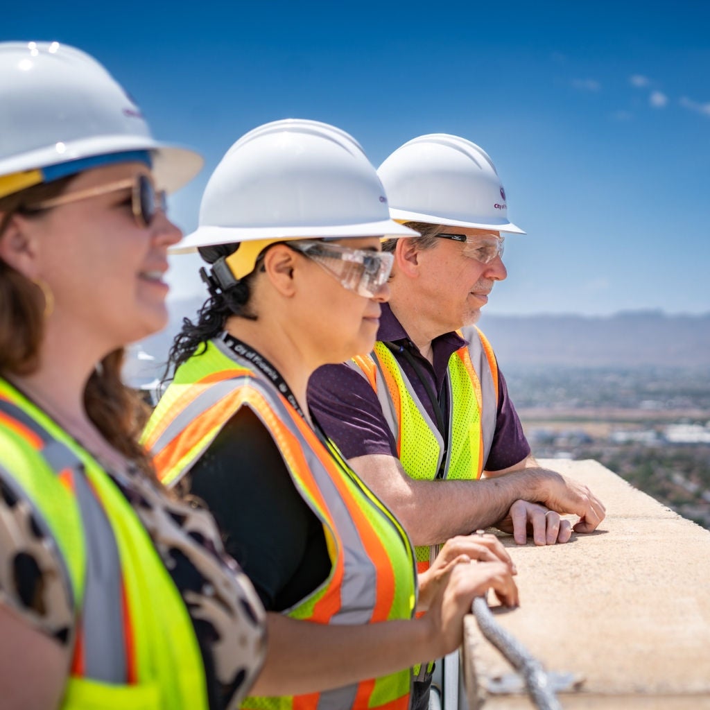 Woman in long sleeve shirt in front of electrical panels