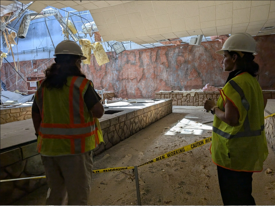 Construction workers standing inside the former Fry's Electronics before demolition