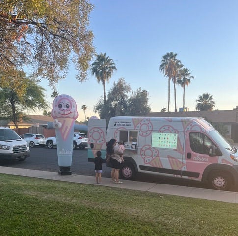 two people standing in line for the ice cream food truck