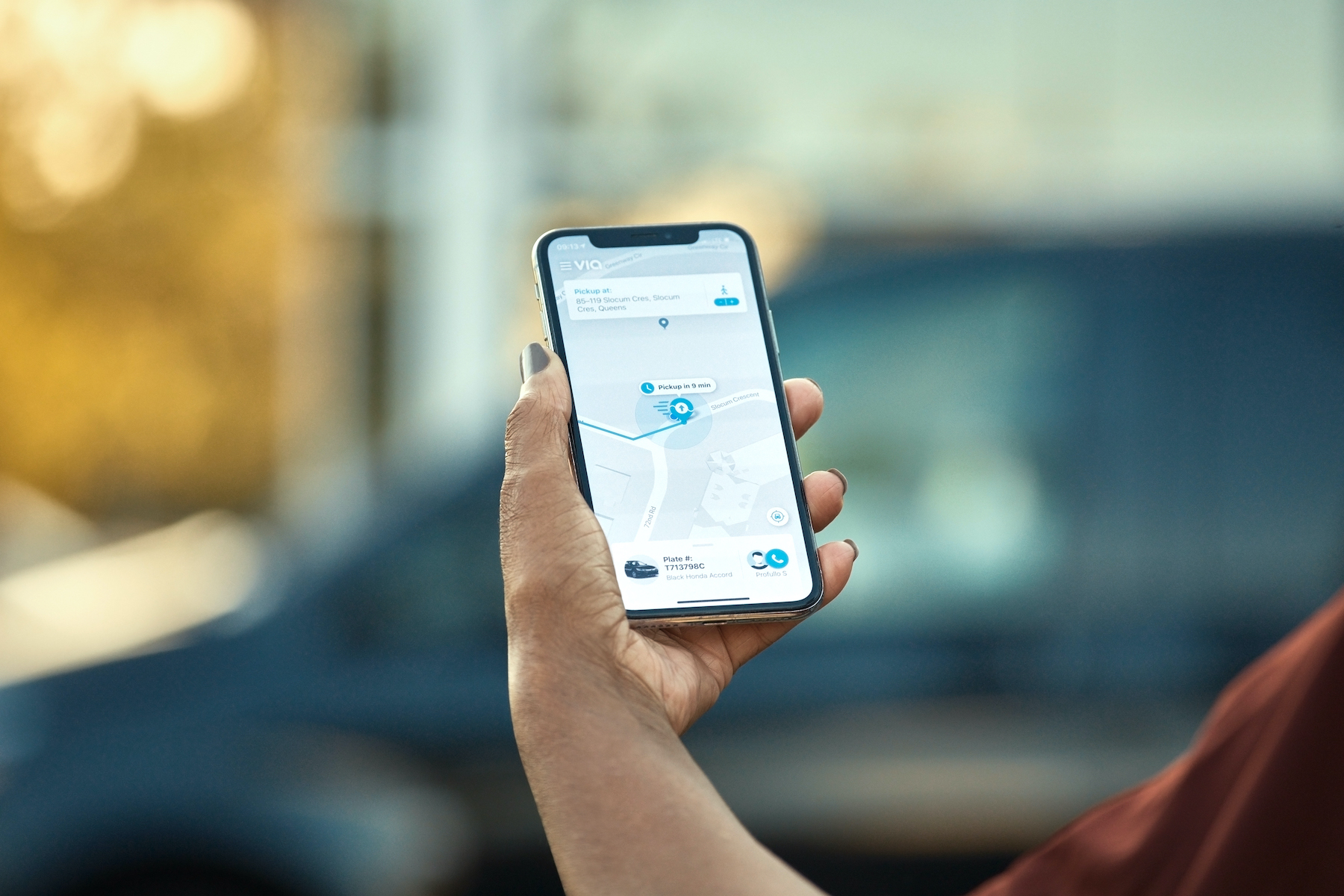 A picture of a woman's hand holding a phone that has an app opened up to the shared-ride app. 