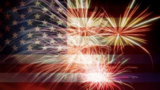 Fireworks in the foreground with the American flag in the background