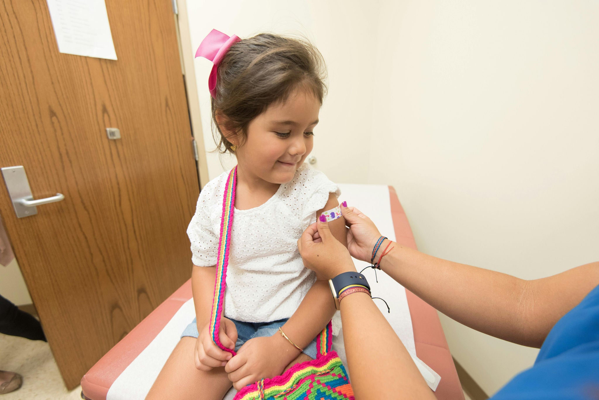 Child getting a bandage put on after receiving a vaccination