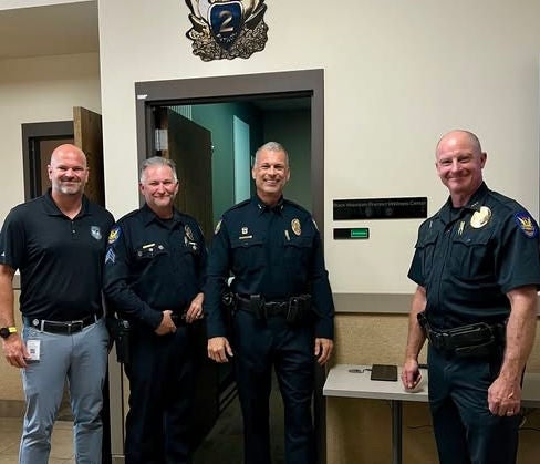 Black Mountain Precinct leaders along with Police Foundation leaders smile after holding a ribbon cutting and dedication ceremony for the new wellness center located at the precinct.