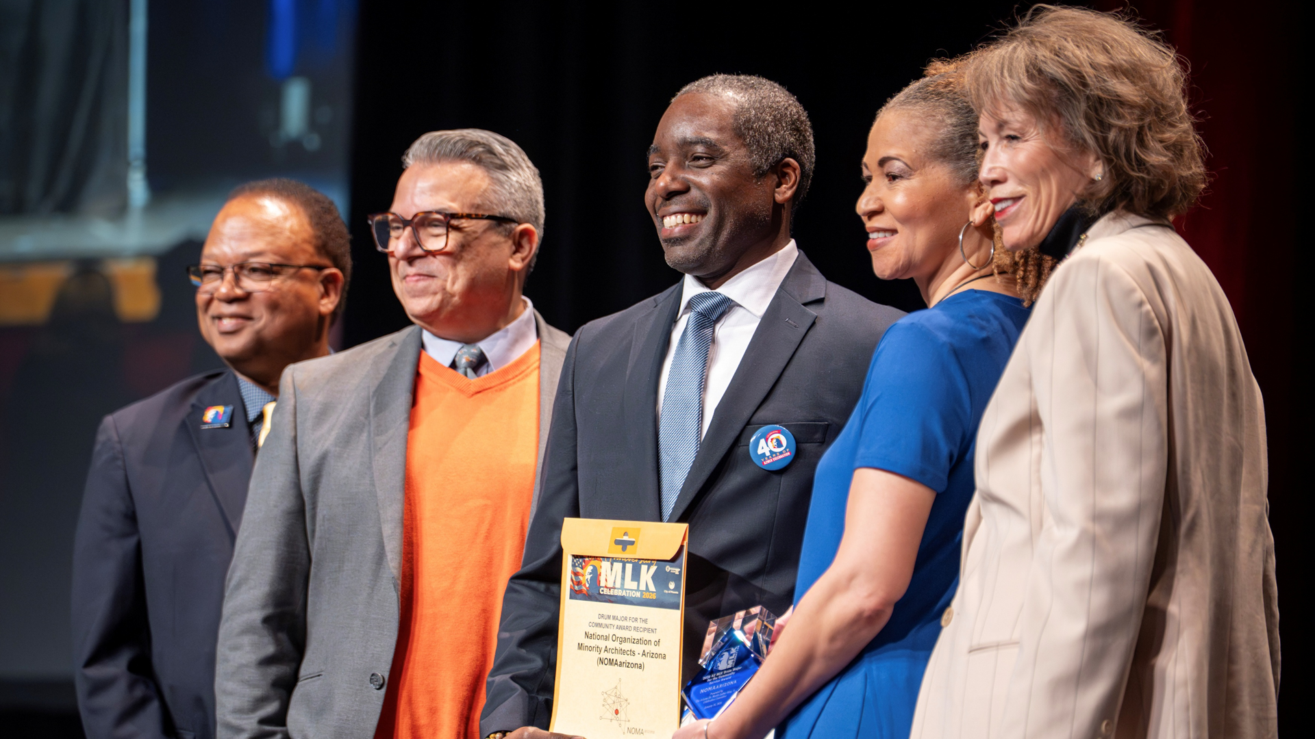 The AZMLK "Drum Major for the Community" Award recipient is taking a group photo along with other leadership. 