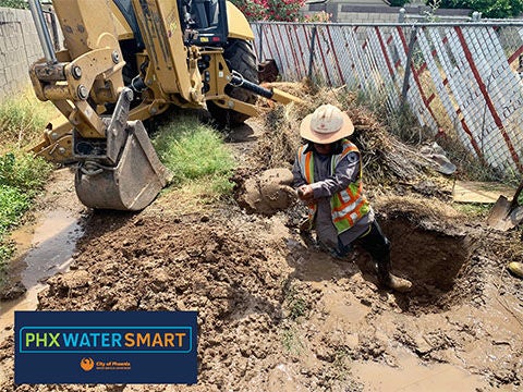 photo of utility worker working on a broken water line