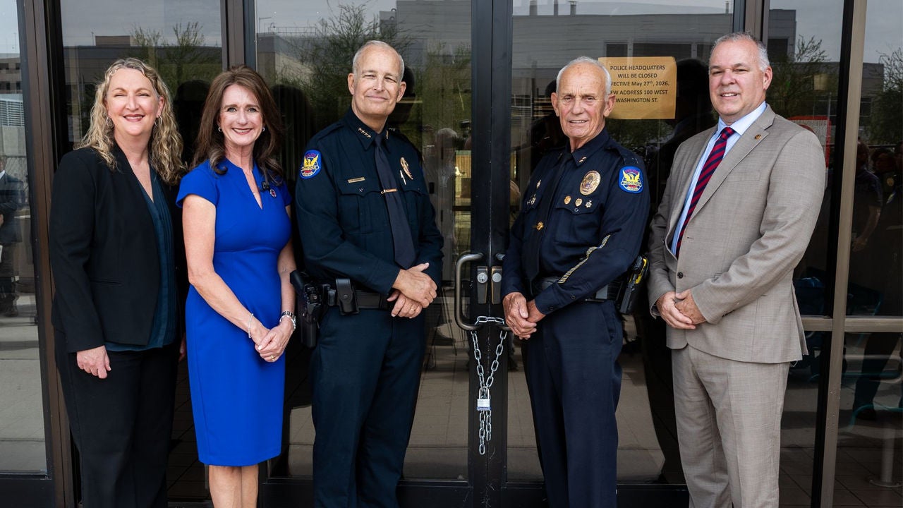 Assistant city manager Lori Bays, Phoenix Councilwoman Ann O'Brien, Police Chief Matt Giordano, Commander Henry Cusson, and City Manager Ed Zuercher smile for a picture at the chained doors of 620 west Washington following a decommissioning ceremony for the old Phoenix Police Headquarters