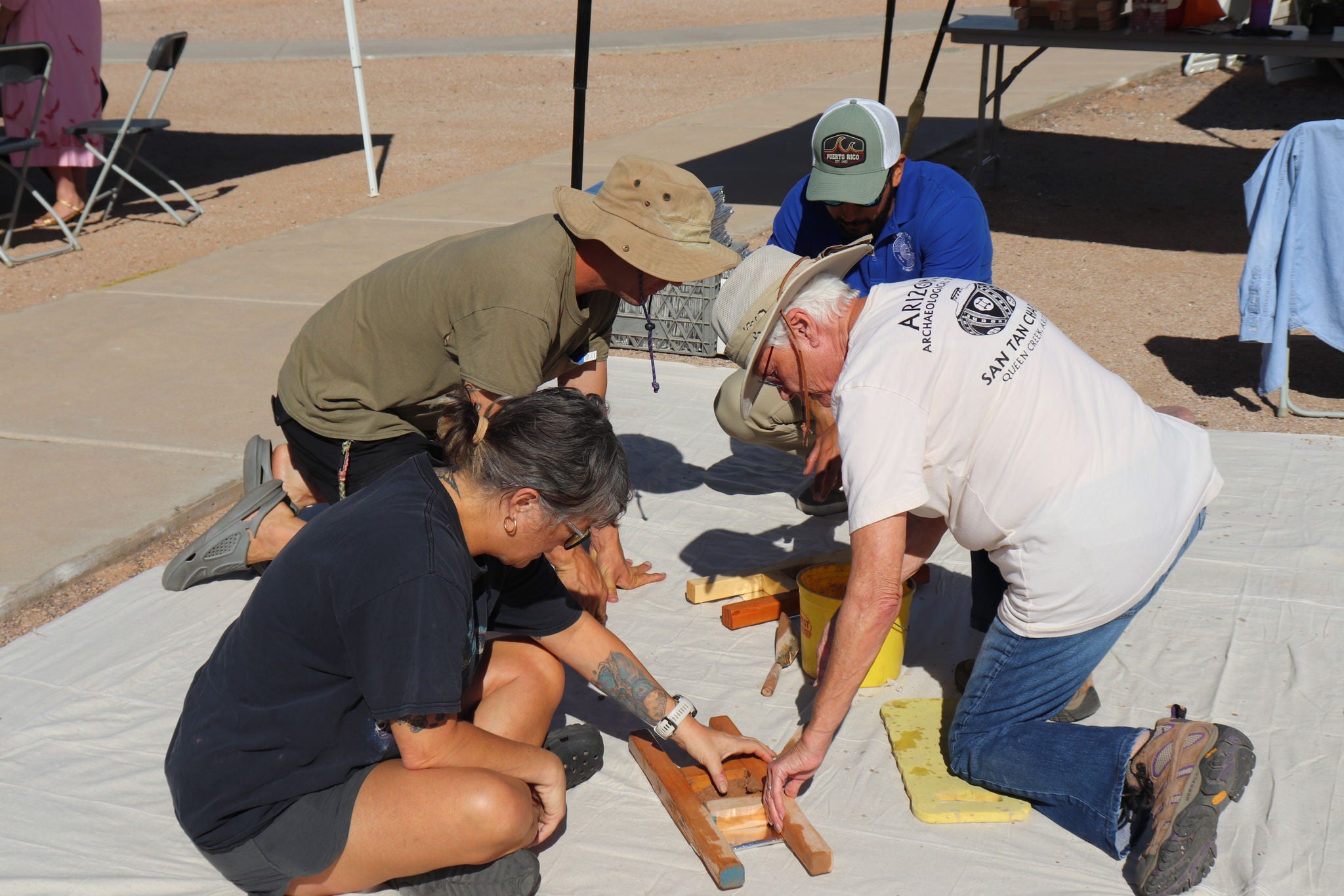 Group of adults learning to make adobe bricks.