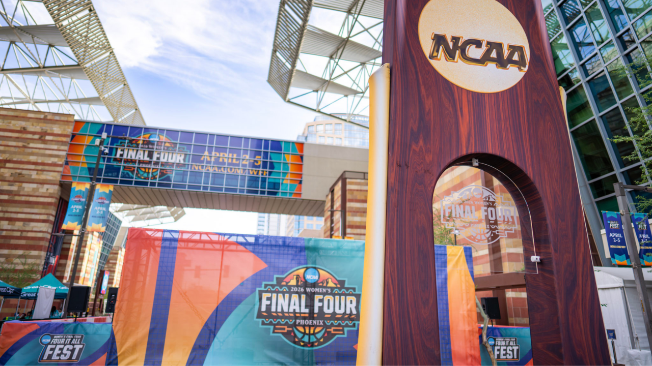 Exterior of Phoenix Convention Center during 2026 NCAA Women's Final Four with various signage and oversized NCAA Trophy at foreground