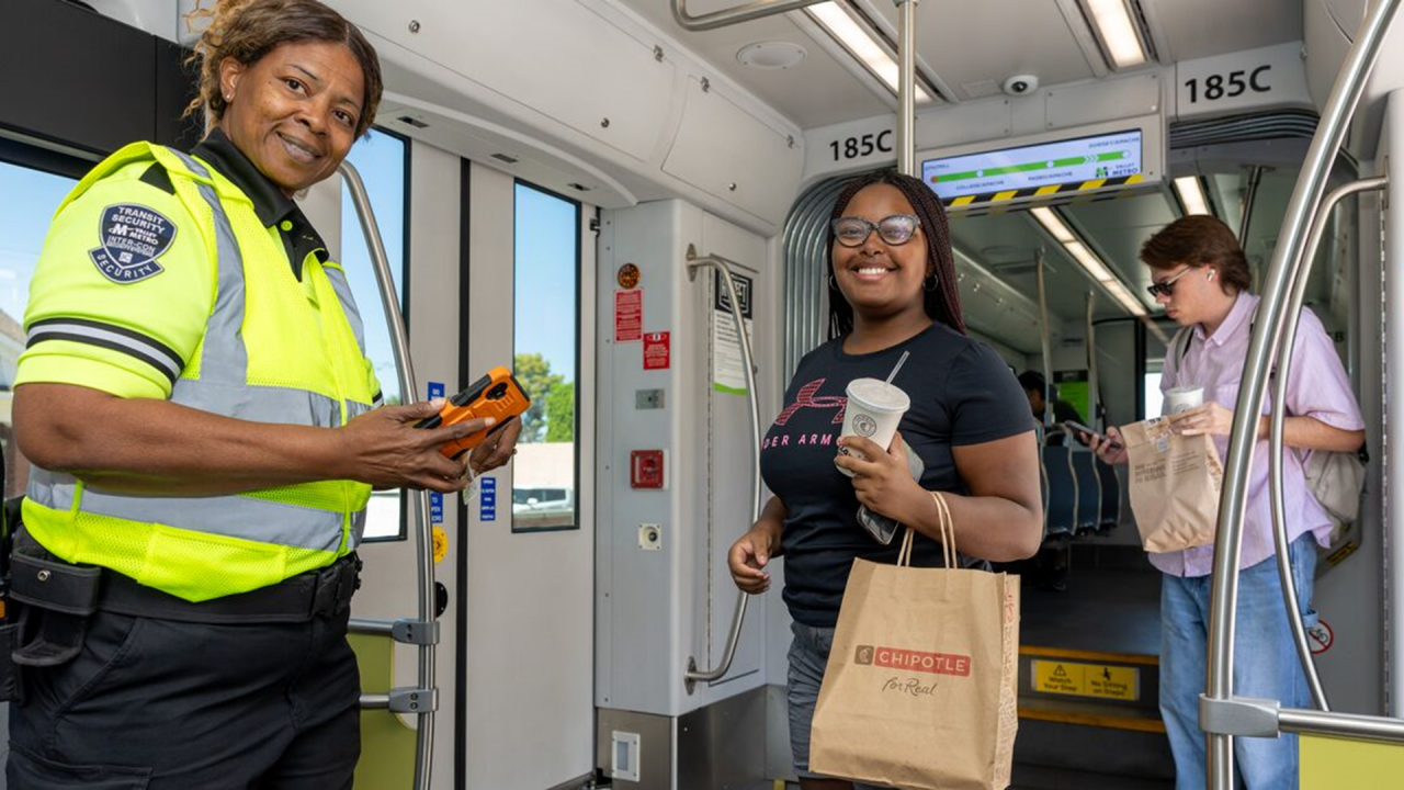 A  Valley Metro security member with a light rail rider. 
