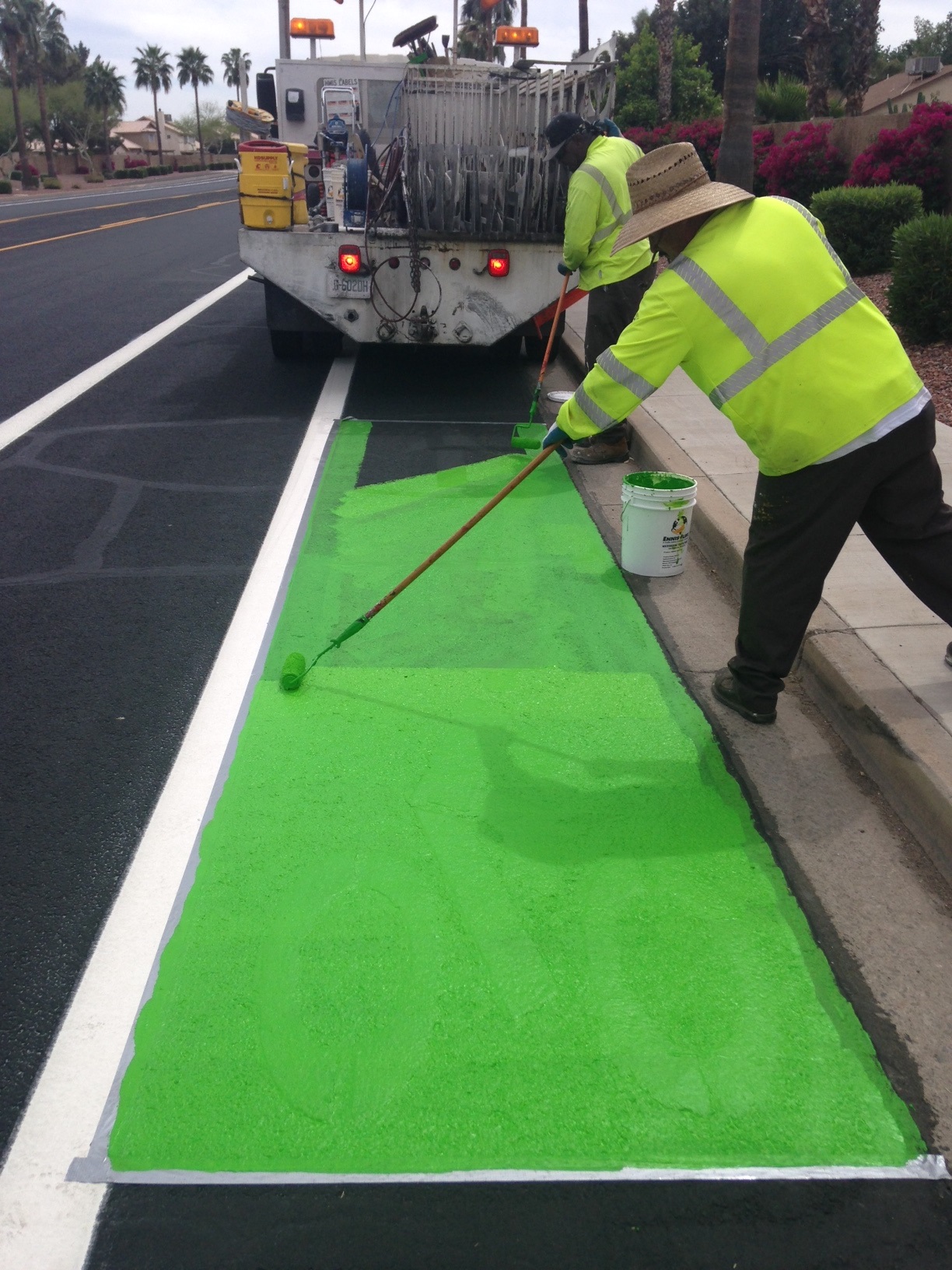 Worker painting green bike lane