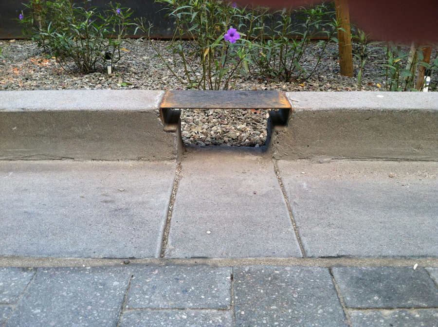 Photo of curbing with a cut in it for water drainage