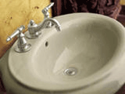Oval-shaped ceramic sink with chrome faucets.