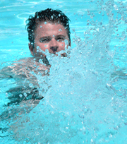 Man splashing water in a swimming pool.