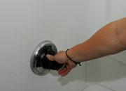 Hand tightening a shower faucet.
